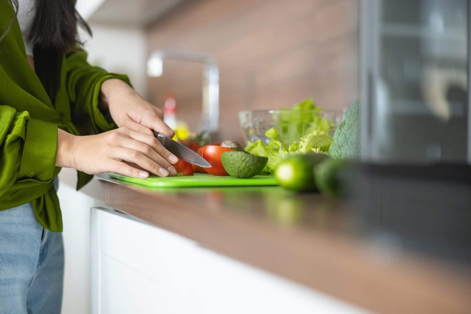 Woman prepares ingredients from meal kit delivery. Asking are meal kits worth it?