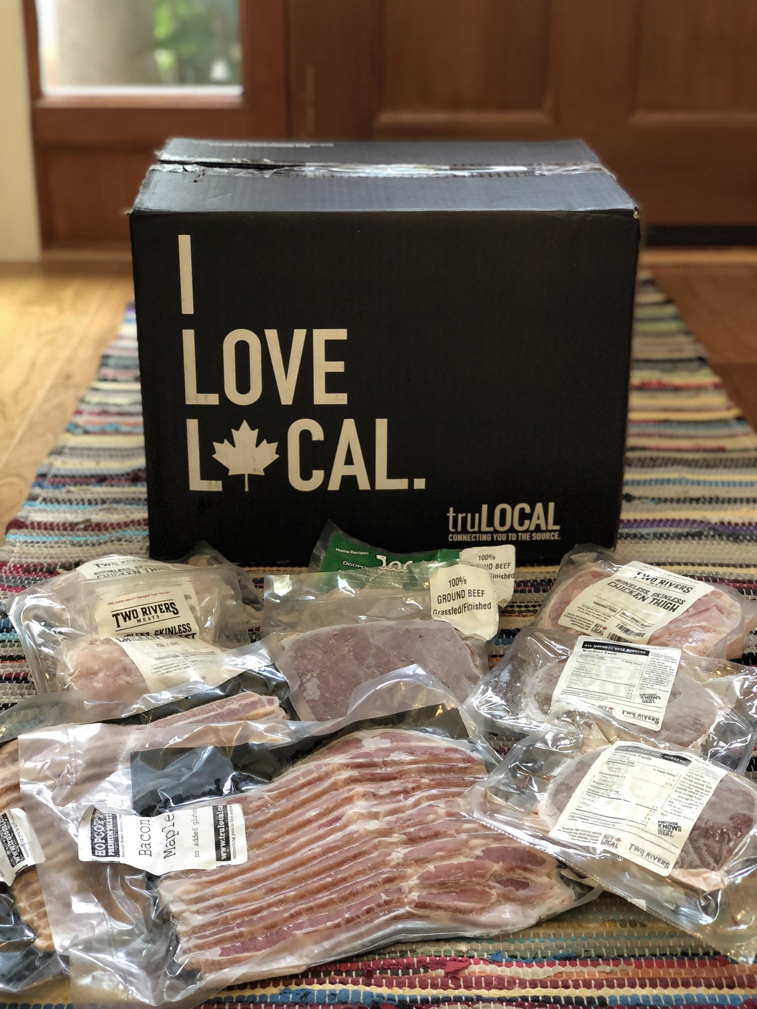 truLOCAL box with vacuum-sealed local meat: Two Rivers chicken, grass-fed ground beef, and maple bacon.